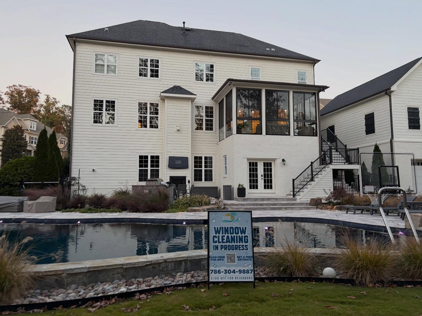 Estate home with pool after a full window cleaning, 305 Prestige yard sign by the water